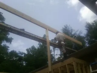 Carpenter setting a ridge beam over a new addition frame — Ice Dam Removal by Roofing Brothers in Hays