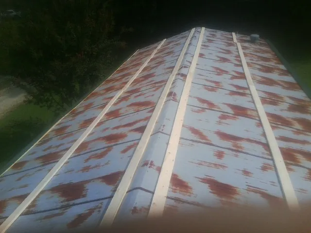 Rusted metal roof panels with new wood purlins before replacement — Storm Damage Roof Repair in Hays by Roofing Brothers