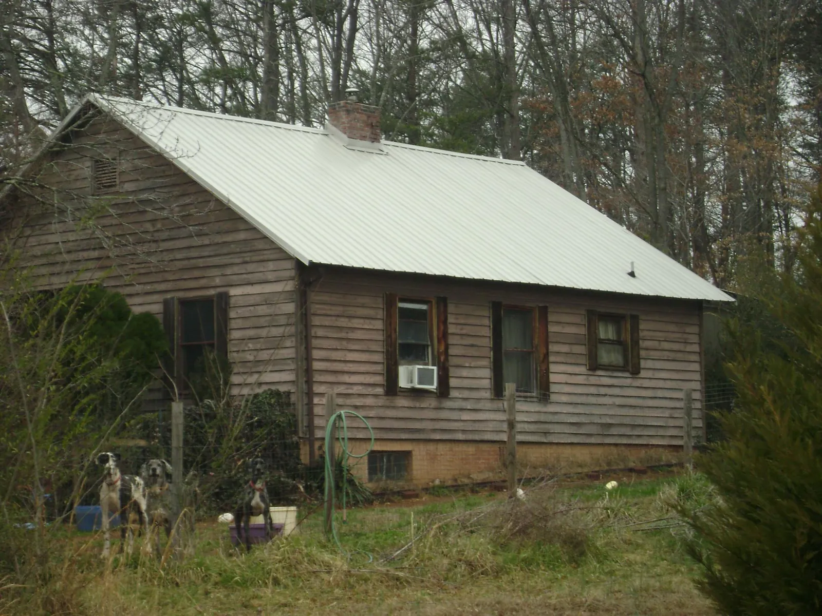 White metal roof on an old wood sided farmhouse, from a Asphalt Shingle Roof Repair job in Hays